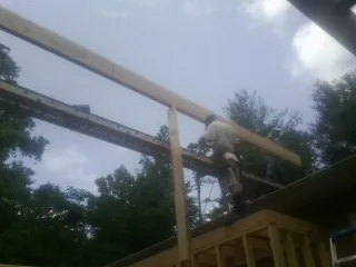 Carpenter setting a ridge beam over a new addition frame — Ice Dam Removal by Roofing Brothers in Louisville